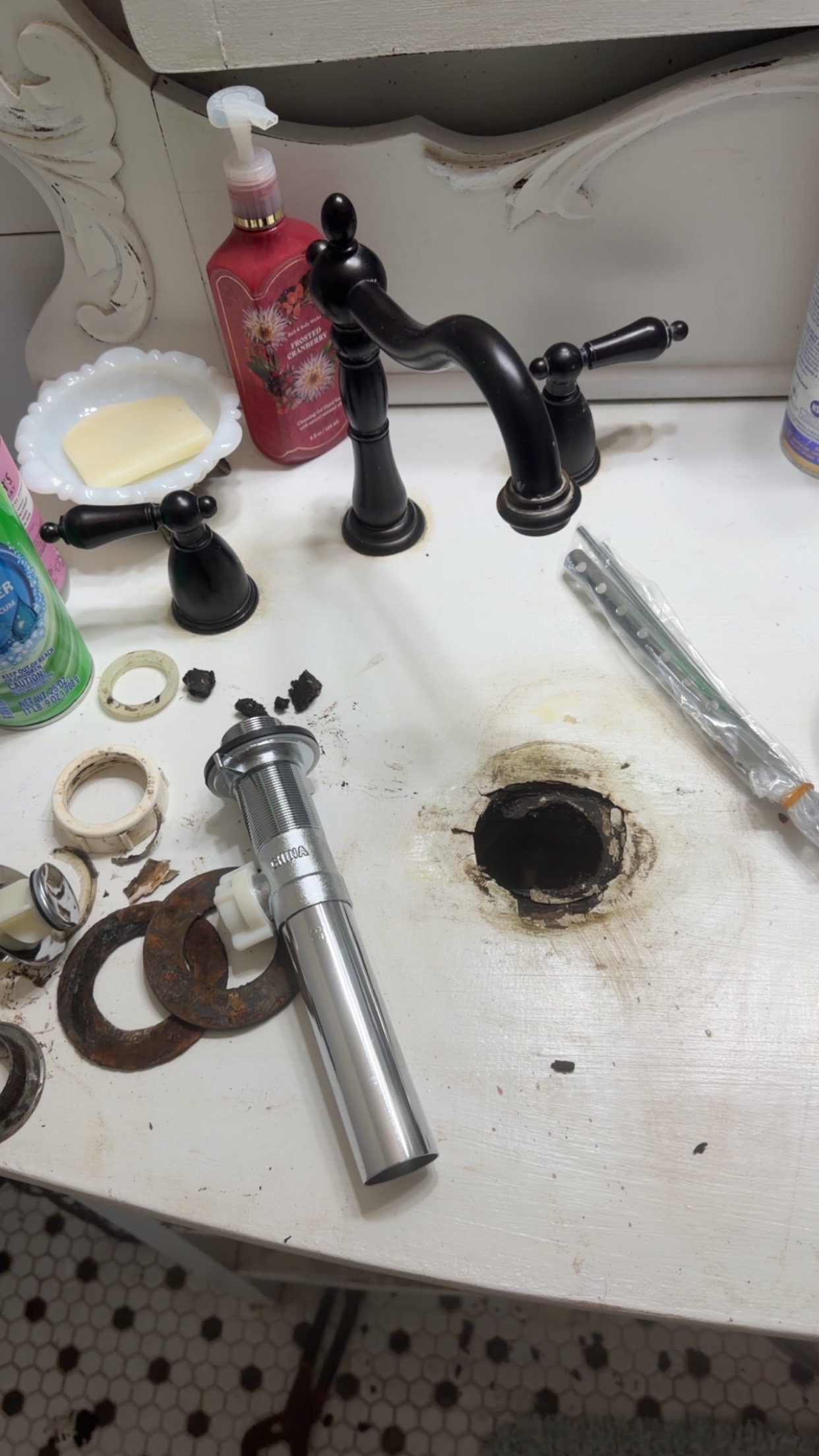 Old sink drain removed and replacement drain assembly ready for installation