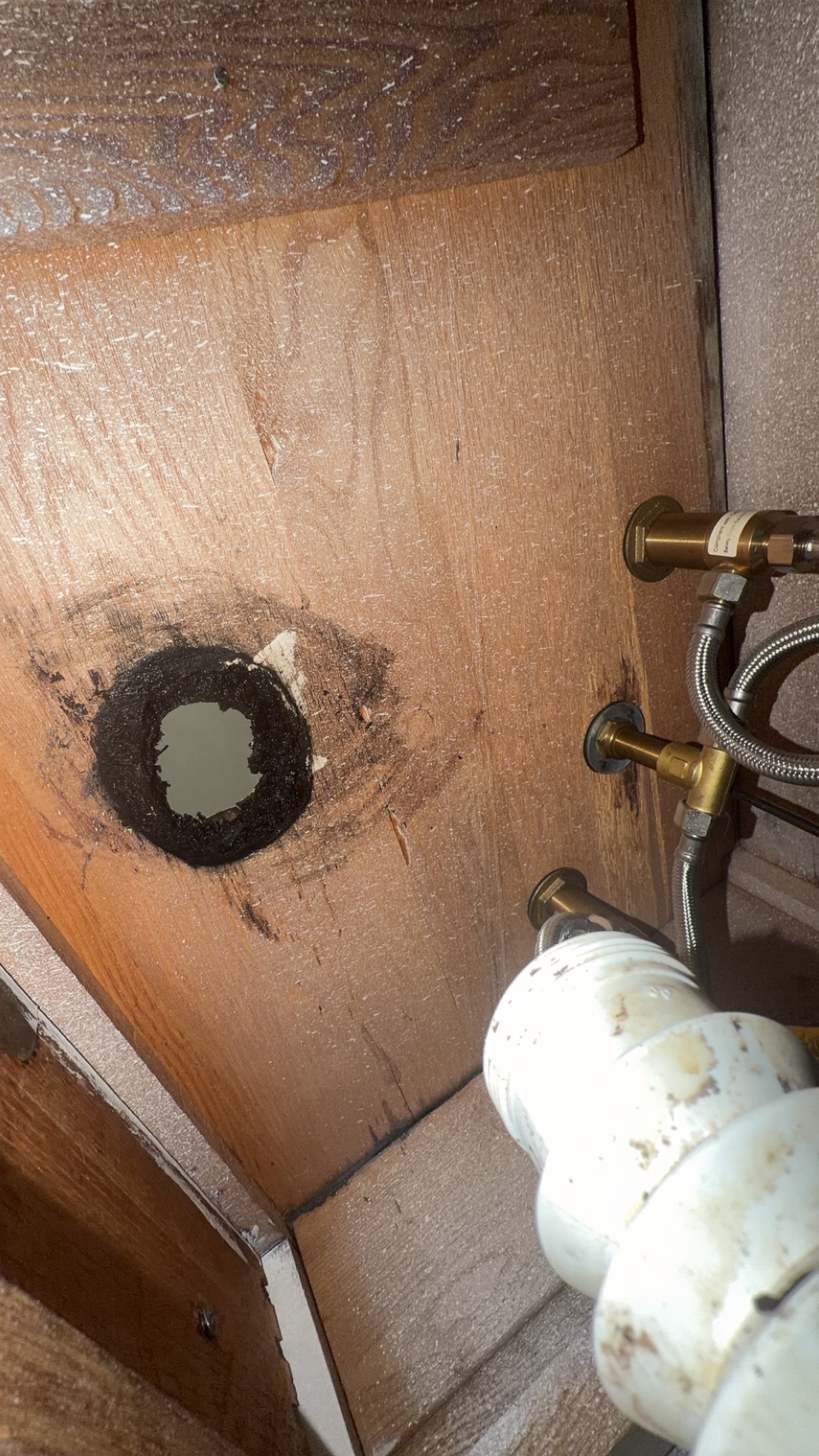 Underside of sink during removal of the old drain connection